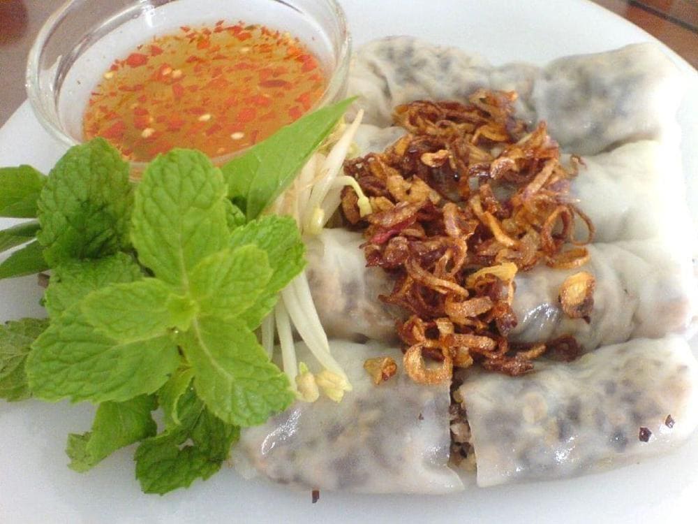Translucent steamed rice rolls garnished with fried shallots and fresh herbs